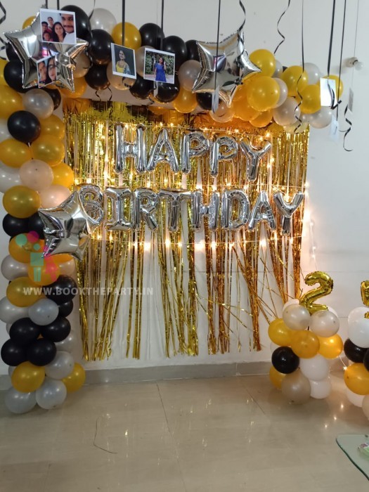 Black and gold balloons decor with streamers